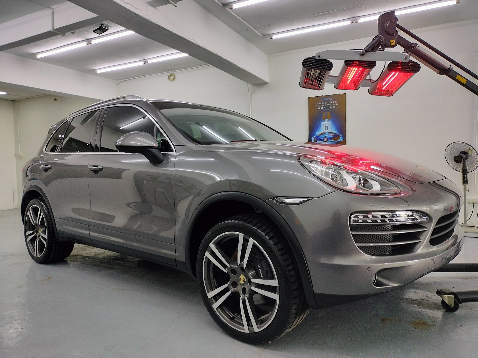 Porsche Cayenne under infrared curing lamps at Ria Auto Detailing